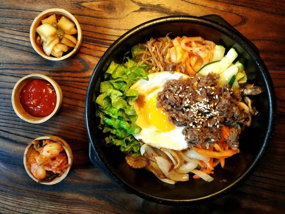 Na imagem temos uma mesa com um prato típico da culinária Coreana