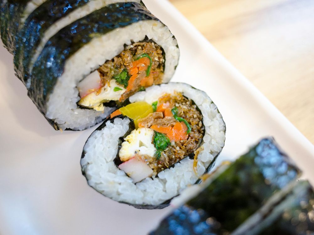 Imagem do Gimbap comida típica sul coreana, consiste em um rolinho de arroz, com legumes, presuntos entre outros produtos típicos