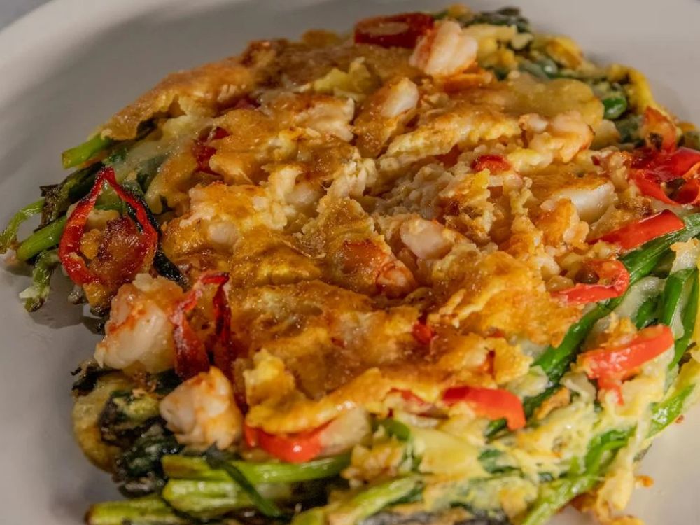 Imagem do Haemul Pajeon prato da culinária coreana que lembra uma panqueca de legumes com frutos do mar