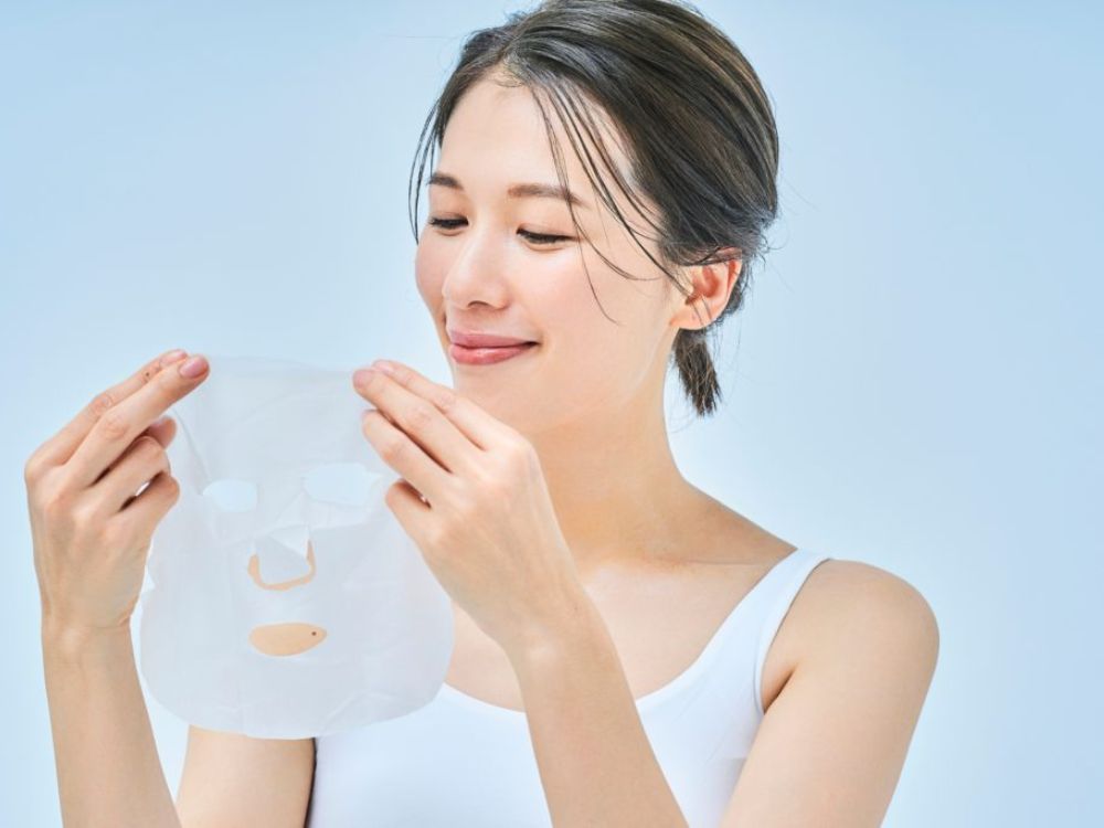 Imagem retrata uma sul-coreana colocando uma Máscaras de biocelulose com ingredientes fermentados